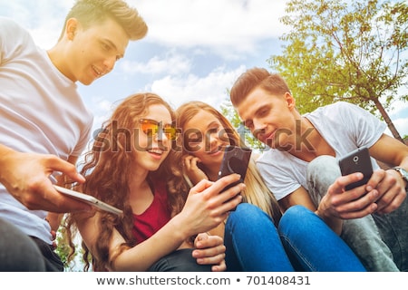 Foto stock: Happy Teenagers Looking At A Smartphone