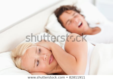 Stok fotoğraf: Annoyed Woman Awaken By Her Fiances Snoring In Their Bedroom