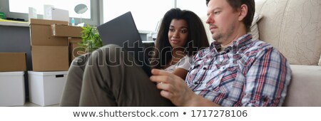 Foto stock: Happy Couple Sitting Together Watching Something Intresting On T