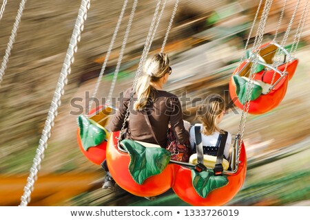 Foto stock: Child With Mother Have Fun In The Chair Of The Carousel