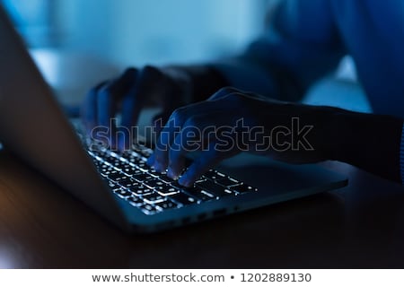 Foto stock: Hacker Sitting At Desk Hacking A Laptop