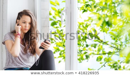 Foto stock: Sad Pretty Teenage Girl Sitting On Windowsill