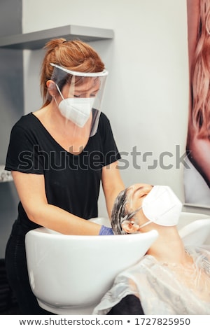 Foto stock: Hairdresser Washing Hair Of Client