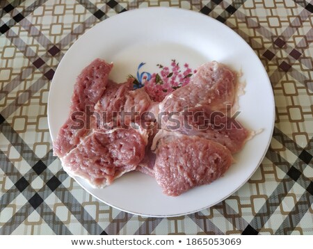Stok fotoğraf: Pieces Of Raw Meat On A White Plate Is Isolated On A White Backg