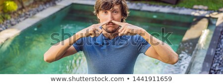 [[stock_photo]]: Banner Long Format Young Man With Disgust On His Face Pinches Nose Something Stinks Very Bad Smel