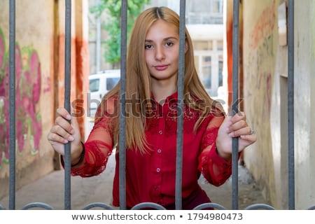 Stok fotoğraf: Female Hands Behind Prison Yard Bars