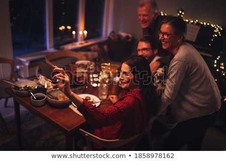 [[stock_photo]]: Woman Calling On Smartphone At Christmas Dinner