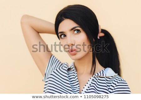 Stok fotoğraf: Cute Young Woman Has Dreamy Expression Keeps Lips Round Has Make Up Makes Hair In Pony Tail Drea