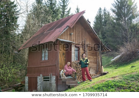 Stockfoto: Beautiful Young Woman At An Old Rustic Cottage