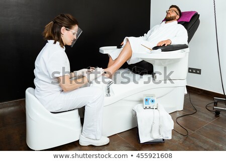 Foto stock: Man Doing Pedicure In Salon Beauty Concept