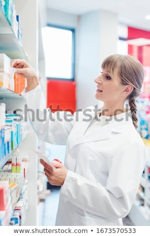 Stock fotó: Pharmacist Or Chemist Woman Sorting Drugs In Shelves In Her Pharmacy