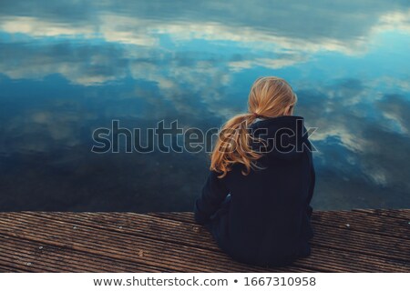 Foto d'archivio: Young Blonde Sits On Footbridge