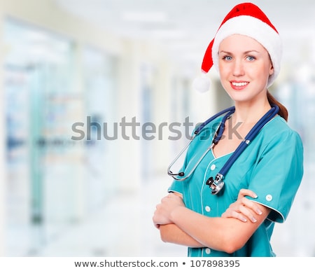 Stok fotoğraf: Doctor Wearing Santa Hat In A Hall Of A Hospital