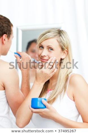Stock foto: Young Man Applying Lotion On Her Face