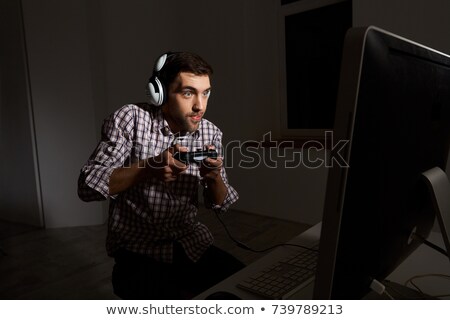 Foto d'archivio: Portrait Of Happy Man Playing Video Games On Computer Wearing H