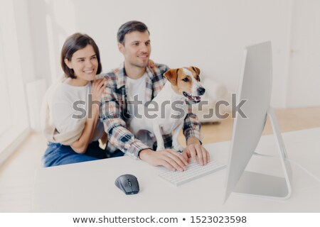 Foto stock: Positive Young Wife And Husband Read Publication Online Sit In Front Of Computer Watch Favourite F