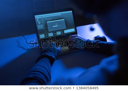 Stock photo: Hacker With Progress Bar On Computers In Dark Room