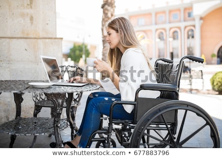 Foto stock: Ulher · adulta · com · deficiência · em · cadeira · de · rodas, · trabalhando · em · seu · laptop