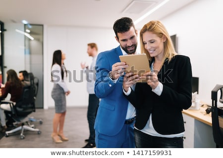 Foto stock: Colleagues Using Digital Tablet In Office