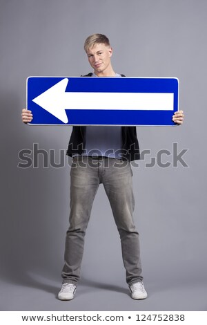 Stok fotoğraf: Pleased Man Holding Horizontal Direction Arrow Sign