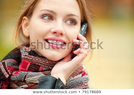 Foto d'archivio: Red Haired Girl Calling By The Phone In The Autumn Park