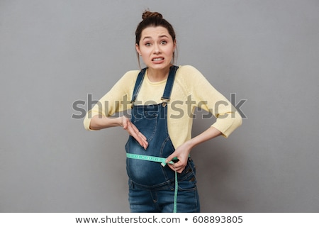 Zdjęcia stock: Shocked Pregnant Woman Standing Isolated With Centimeter