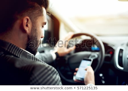 Stock photo: Man Driving Car And Using Mobile Phone For Texting