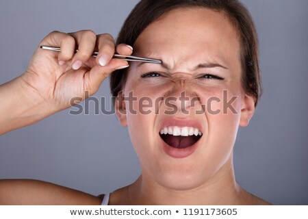 Zdjęcia stock: Woman Having Pain While Plucking Eyebrow Hair With Tweezers