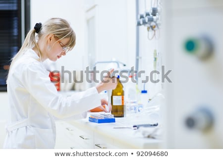 Foto stock: Young Beautiful Biotechnology Chemist Working In The Lab