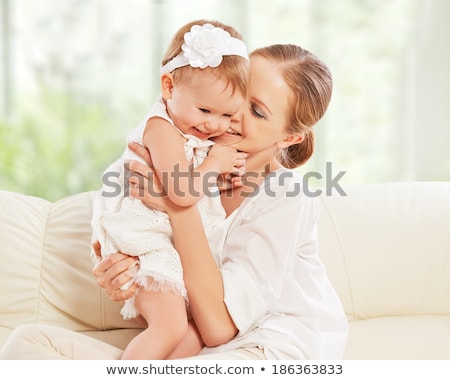 Stok fotoğraf: Happy Family Mother And Baby Daughter Plays On The Sofa