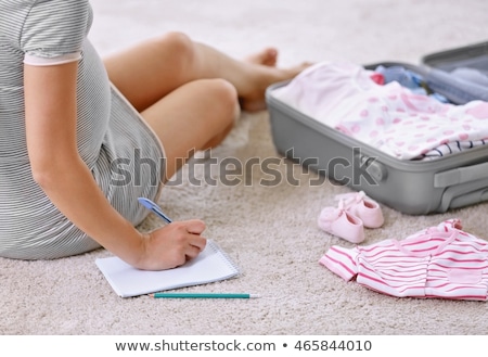 Stockfoto: Pregnant Woman Packing Bag For Maternity Hospital