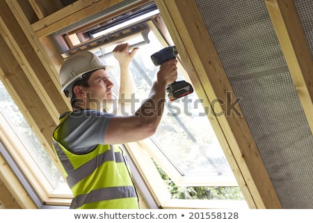 Stock photo: Construction Worker Using Drill To Install Window