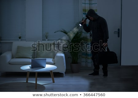 Foto d'archivio: Robber Holding Flashlight Over Laptop At Home