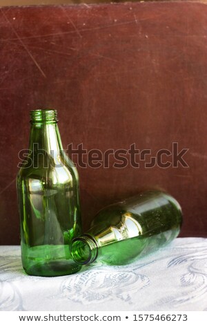 Foto stock: Uas · garrafas · de · vinho · vazias · transparentes · verdes · e · marrons · no · branco