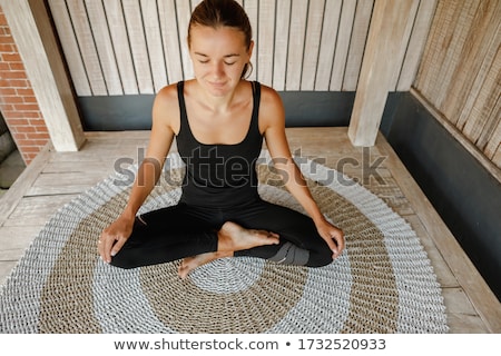 Stockfoto: Young Woman Is Practicing Yoga In The Morning On Her Balcony With A Panoramic View Of The City And S