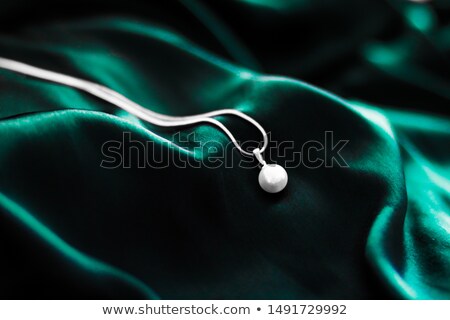 Stockfoto: Luxury White Gold Pearl Necklace On Dark Emerald Green Silk Back