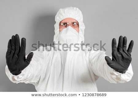 Foto d'archivio: Medical Scientist In Protective Clothing Gesturing Stop Sign In