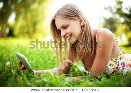 Foto d'archivio: Beautiful Woman With Tablet Computer In Park Garden