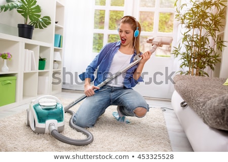 Stock photo: Attractive Cheerful Woman Is In The Room With Vacuum Cleaner