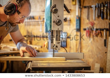 Foto stock: Carpenter On The Band Saw In His Wood Workshop