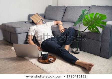Foto d'archivio: Young Man Sleeping On Laptop At Desk