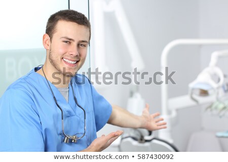 Foto stock: Dentist And Assistant Smiling At Camera Inviting You To The Chai