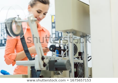 Stock photo: Worker Checking Textile Label Fresh From The Printing Machine