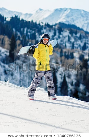 Stok fotoğraf: Female Snowboarder Walking With Her Snow