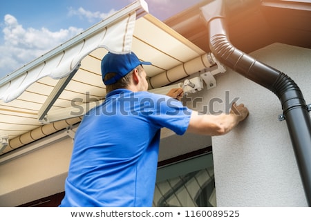 Сток-фото: Worker Install An Awning On The House Wall Over The Terrace Wind