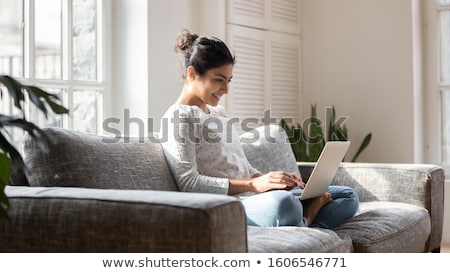 Foto stock: Smiling Woman Looking At Laptop