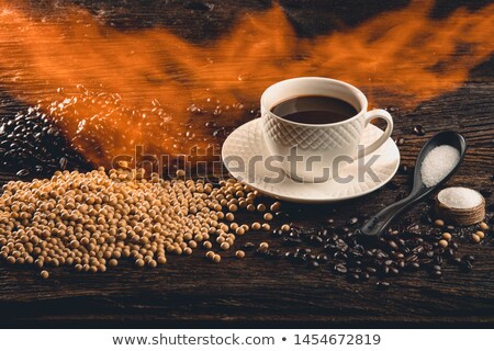 Stockfoto: Cup In Pile Of Roasted Beans And Regular Coffee