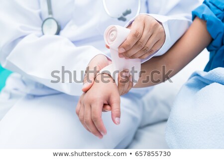 Stock photo: Doctor Wrapping Elastic Bandage To Patient