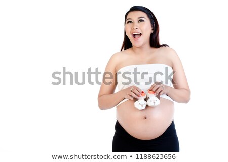 Stock photo: Pregnant Woman Holding Pair Of Baby Shoes Over Her Belly