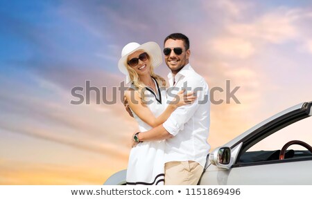 Сток-фото: Happy Couple Hugging Near Convertible Car Over Sky